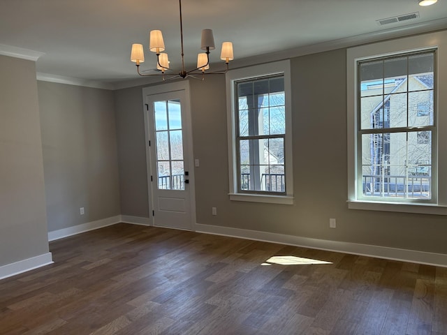 entryway featuring dark wood finished floors, crown molding, a notable chandelier, visible vents, and baseboards