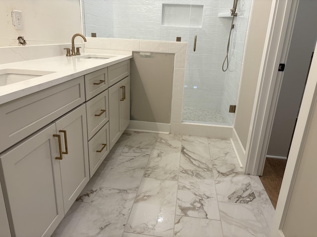 bathroom featuring marble finish floor, double vanity, a sink, and a shower stall