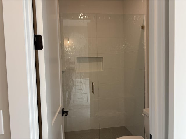 full bath featuring a stall shower and toilet