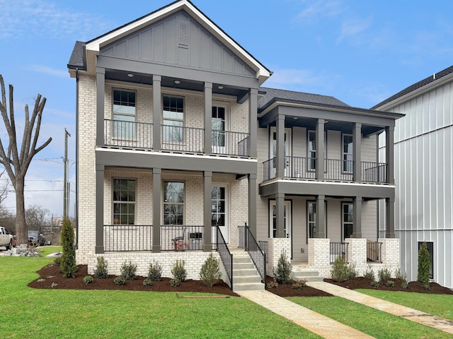 view of front of property featuring a porch, board and batten siding, a front lawn, and brick siding