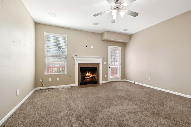 unfurnished living room featuring a fireplace, ceiling fan, and carpet flooring