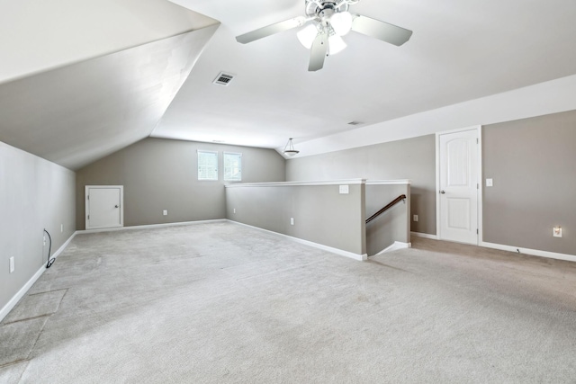 bonus room with vaulted ceiling, light colored carpet, and ceiling fan