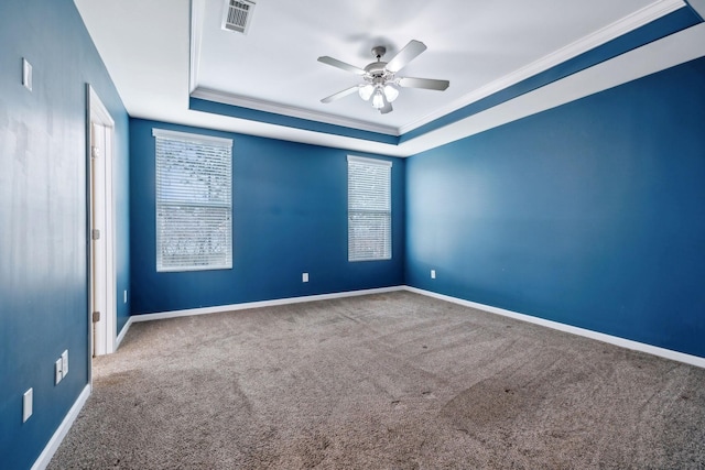 carpeted empty room featuring a raised ceiling, ornamental molding, and ceiling fan