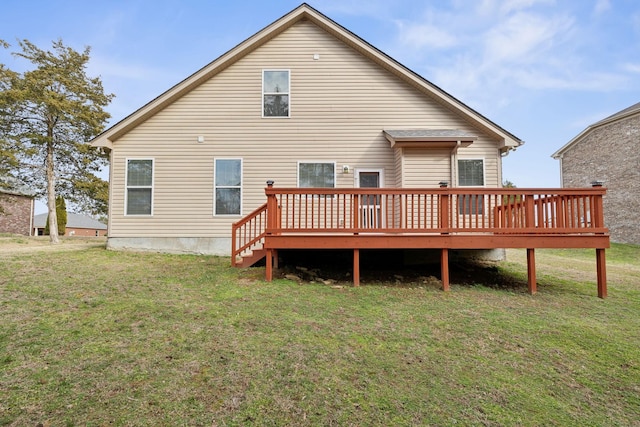 rear view of house featuring a wooden deck and a yard