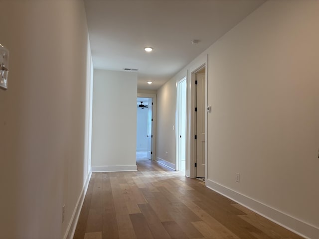 hallway featuring recessed lighting, wood finished floors, visible vents, and baseboards