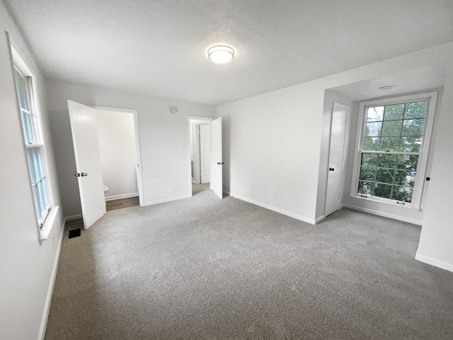 unfurnished room with carpet floors and a textured ceiling