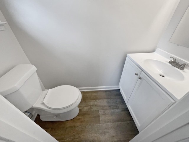 bathroom with hardwood / wood-style flooring, vanity, and toilet