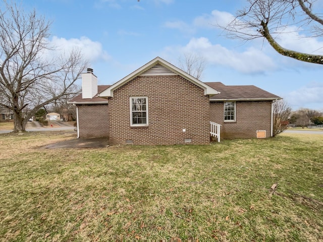 view of side of home with a yard