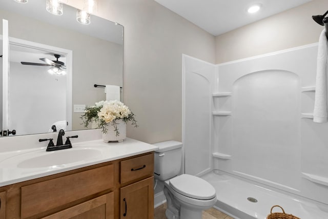 bathroom with a shower, vanity, ceiling fan, and toilet