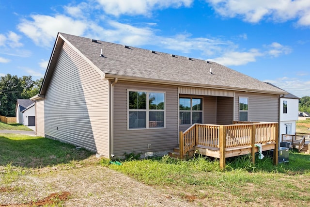 rear view of house with a deck and a lawn