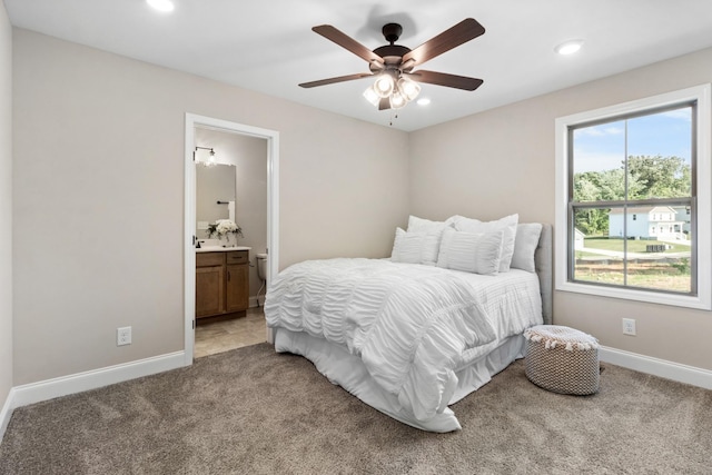 carpeted bedroom featuring ceiling fan and connected bathroom