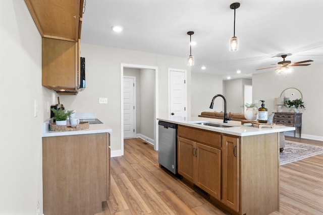 kitchen with sink, hanging light fixtures, a center island with sink, light wood-type flooring, and stainless steel dishwasher