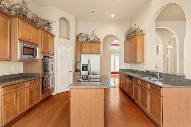 kitchen featuring sink, stainless steel appliances, dark hardwood / wood-style floors, a center island, and kitchen peninsula