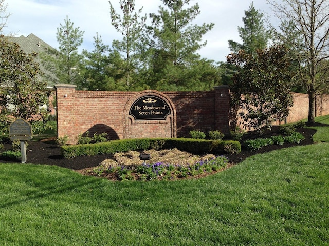 community / neighborhood sign with a yard