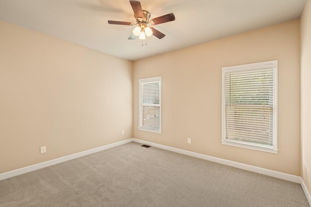 carpeted spare room featuring ceiling fan