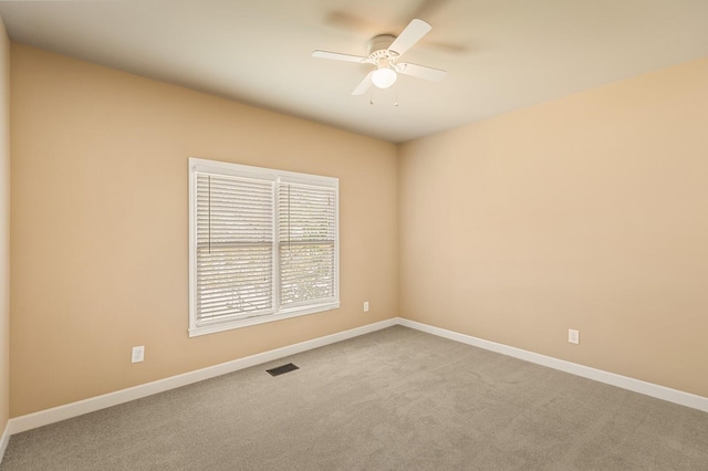 carpeted spare room with ceiling fan