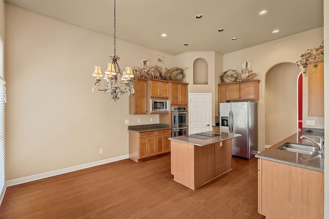 kitchen featuring dark wood-type flooring, appliances with stainless steel finishes, sink, and a kitchen island