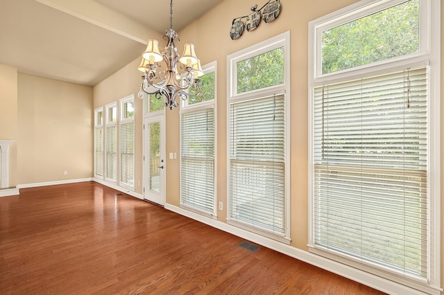 interior space featuring an inviting chandelier, hardwood / wood-style floors, and lofted ceiling with beams