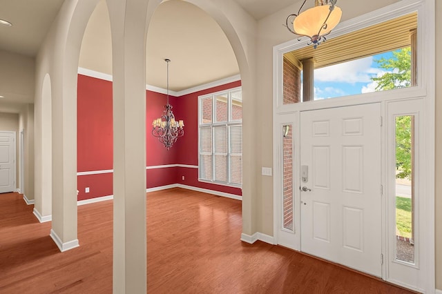 foyer entrance with hardwood / wood-style floors and a notable chandelier