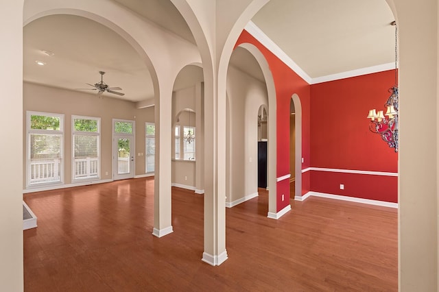 interior space featuring ceiling fan, wood-type flooring, and ornamental molding