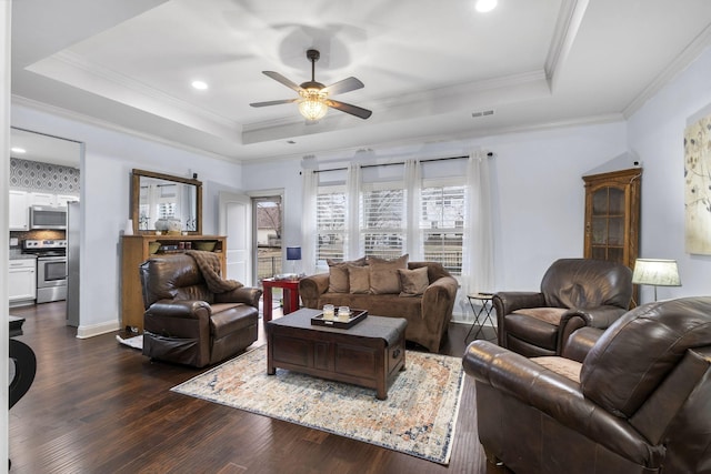 living area featuring dark wood-style floors, a tray ceiling, a ceiling fan, and ornamental molding