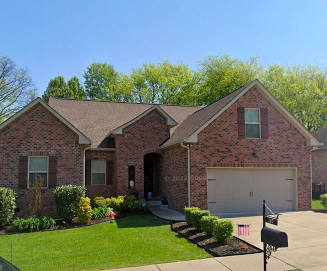 single story home with concrete driveway, roof with shingles, an attached garage, a front lawn, and brick siding