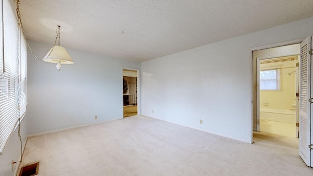 carpeted empty room featuring a textured ceiling