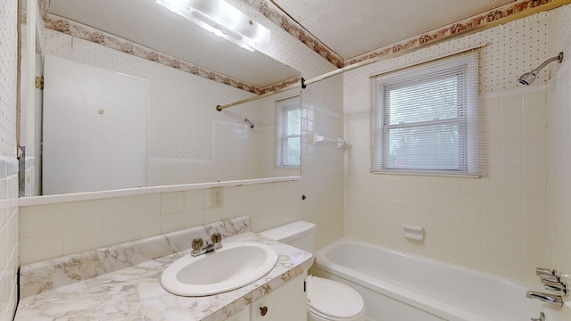 full bathroom with vanity, toilet, and tiled shower / bath combo