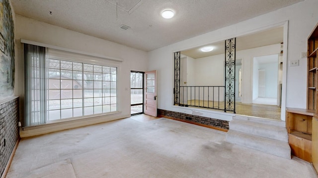 spare room featuring carpet floors and a textured ceiling