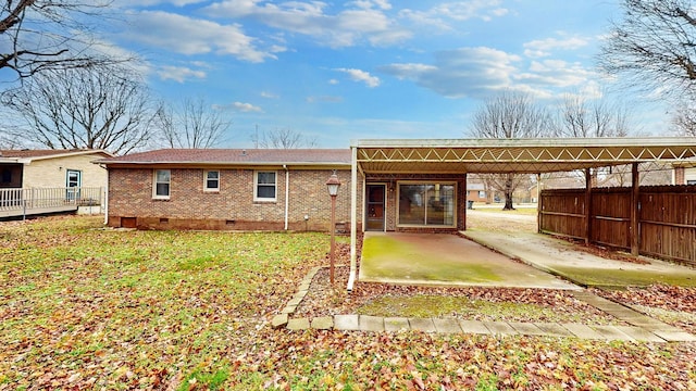 back of property featuring a carport and a yard