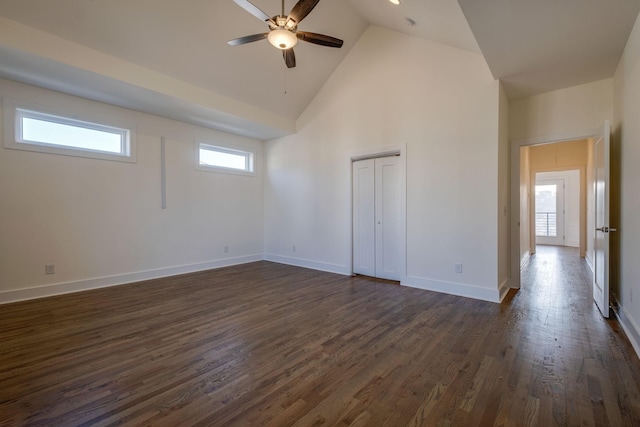 empty room with high vaulted ceiling, dark hardwood / wood-style floors, and ceiling fan