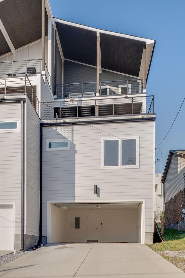 view of side of property with a garage and a balcony