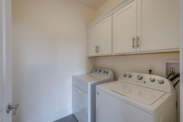 laundry area with independent washer and dryer and cabinets