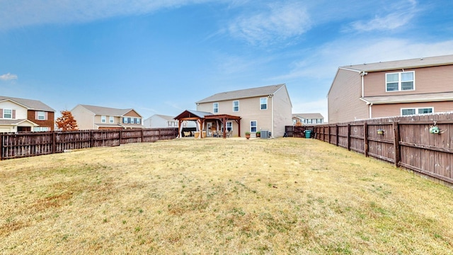 rear view of property featuring a yard, a gazebo, and central air condition unit