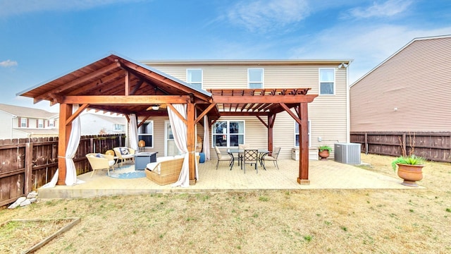 back of house with central AC, outdoor lounge area, a patio area, and a lawn