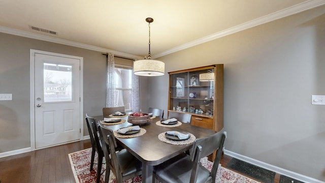 dining room featuring ornamental molding and dark hardwood / wood-style floors