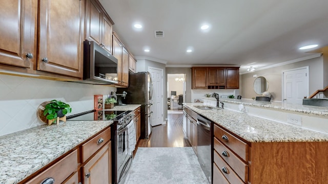 kitchen with stainless steel appliances, ornamental molding, sink, and light stone counters