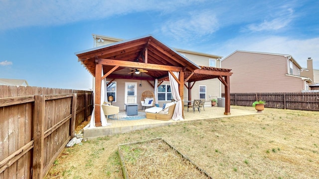 rear view of property featuring a lawn, ceiling fan, and a patio area