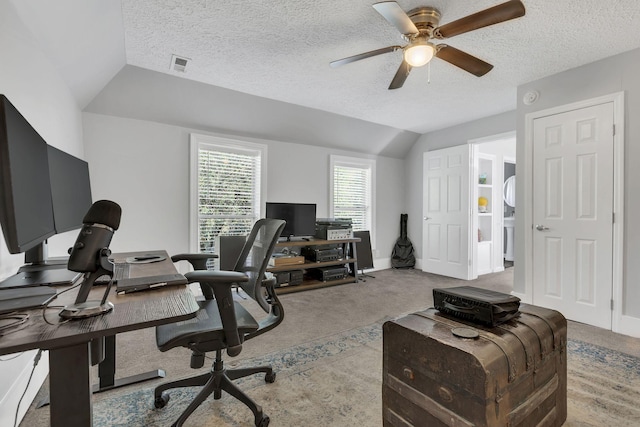 office space with ceiling fan, lofted ceiling, light colored carpet, and a textured ceiling