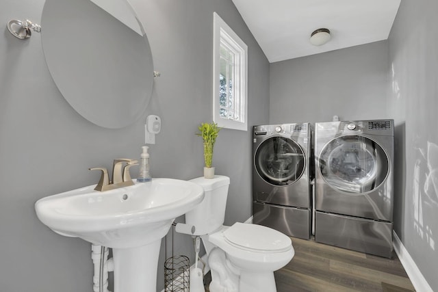 bathroom featuring vaulted ceiling, hardwood / wood-style floors, washer and clothes dryer, and toilet