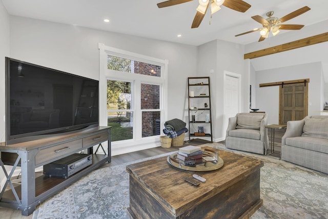 living room with hardwood / wood-style flooring, vaulted ceiling, a barn door, and ceiling fan