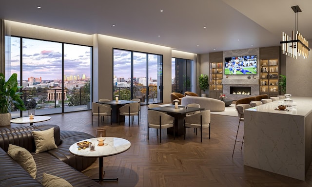 living room with a large fireplace, dark parquet flooring, and a wealth of natural light