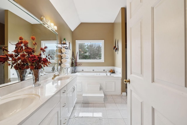 bathroom featuring tile patterned flooring, vaulted ceiling, a washtub, and vanity