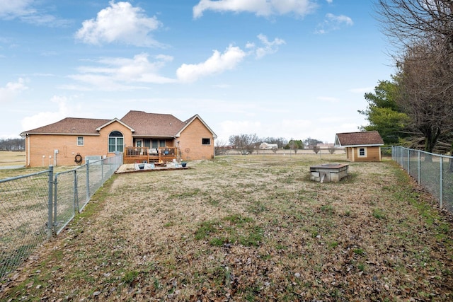 view of yard featuring a wooden deck and a storage unit