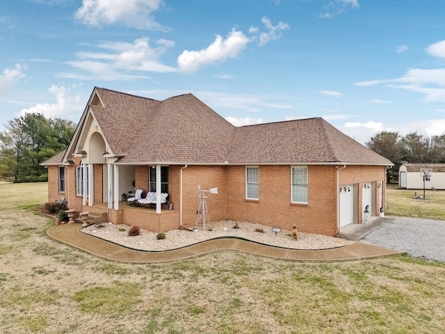 view of side of home featuring a garage, a porch, and a yard