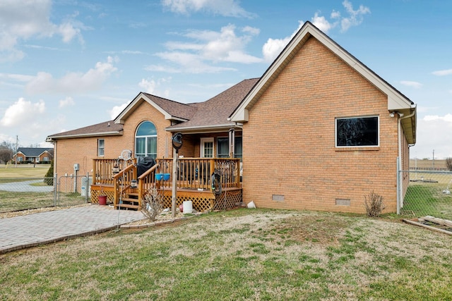 rear view of property featuring a deck and a lawn