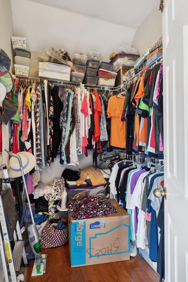 spacious closet featuring hardwood / wood-style flooring and vaulted ceiling