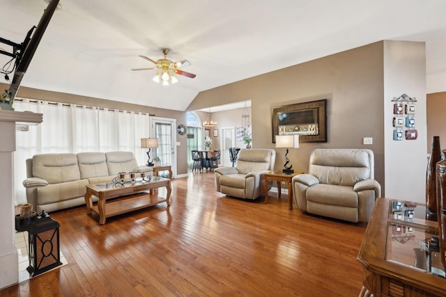 living room featuring hardwood / wood-style flooring, vaulted ceiling, and ceiling fan with notable chandelier