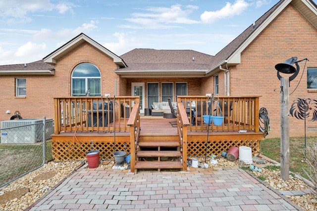 rear view of house with a wooden deck and a patio