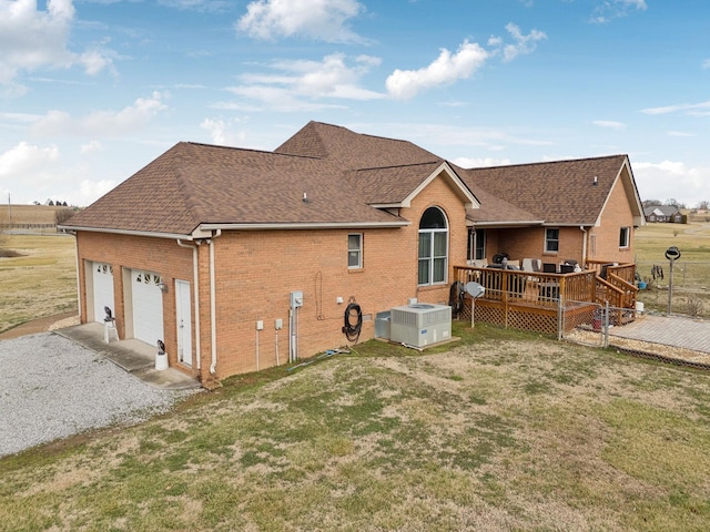 back of house with a wooden deck, a garage, a yard, and central AC unit